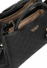 Borsa a mano in ecopelle nera con motivi a logo in rilievo, accessori in metallo dorato, manici doppi e fodera in tessuto beige con nome del marchio stampato.