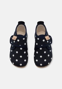 Tamsiai mėlyni audiniai batai su baltais taškeliais, elastinga juosta, minkšta pamušalu ir smėlio spalvos etikete šone. Apvalus pirštas ir lanksti pada.