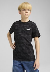 Juodas trumpas rankovėmis marškinėliai su tekstūruotu raštu ir įvairiomis grafikomis, įskaitant baltas "BoardRebels" ir "PUMA" logotipus.