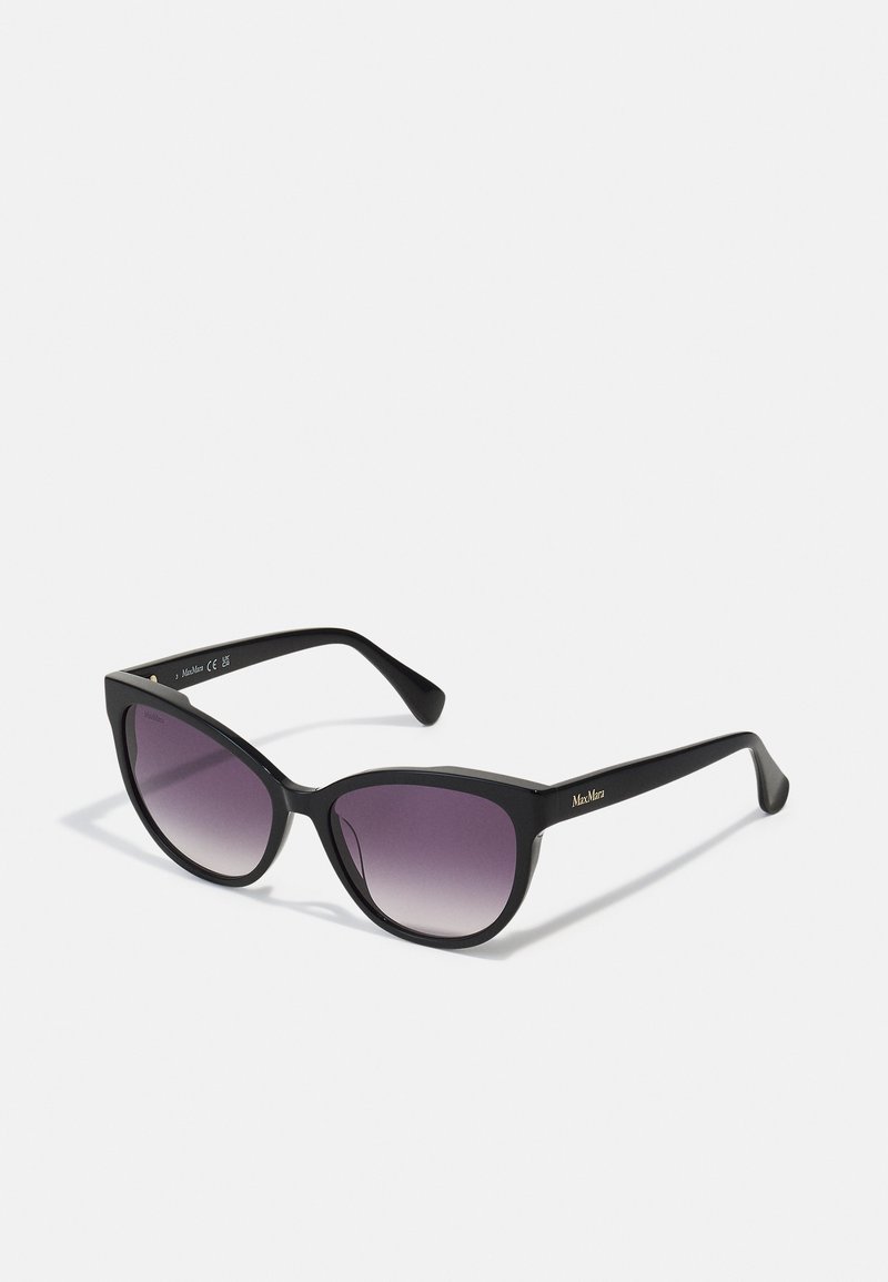 Gafas de sol de estilo cat-eye en negro con lentes morados degradados. Montura de plástico con un acabado mate sólido y un sutil acento de la marca en la patilla.
