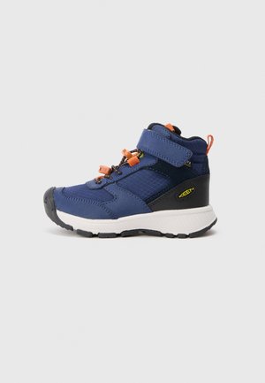 Blue and black children's hiking shoe with white sole, orange pulls, velcro strap, and laces, displayed on a gray background.