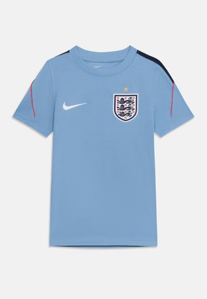 Camiseta de fútbol de Inglaterra de color azul claro con el logo de Nike en el pecho derecho, el escudo de Inglaterra en el pecho izquierdo y detalles en negro y rojo en las mangas.