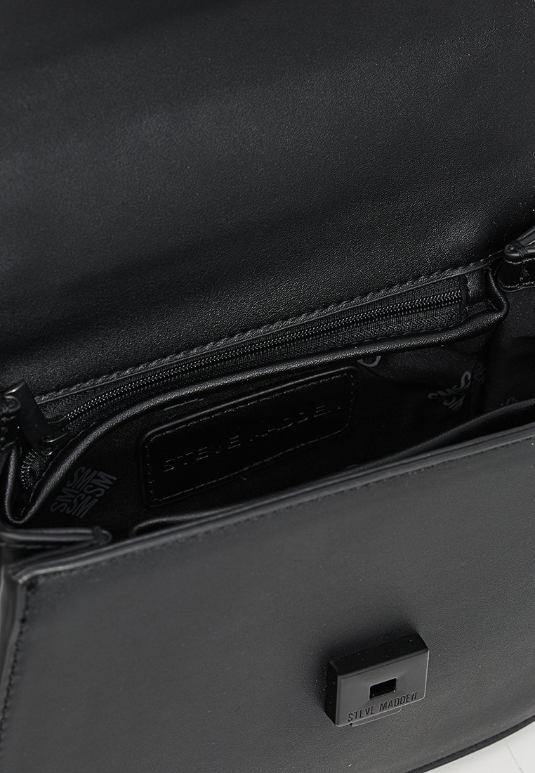 Schwarzlederne Handtasche mit strukturiertem Design, Reißverschlusstasche und Logoetikett. Glatte Textur mit einer minimalistischen Klappe.