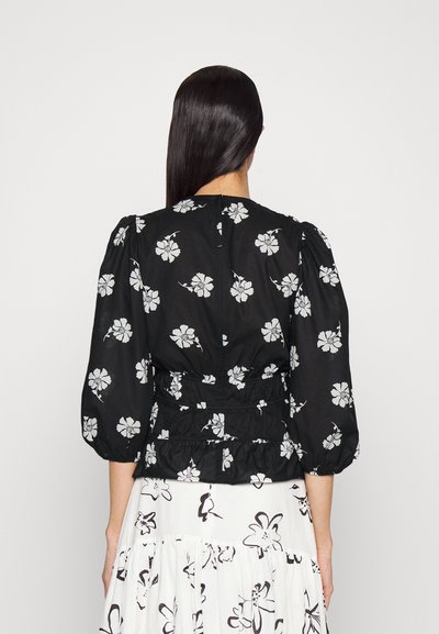 Blusa preta com flores, apresentando mangas bufantes, cintura elástica franzida e padrões de flores brancas. Tecido leve, fecho de zíper nas costas.