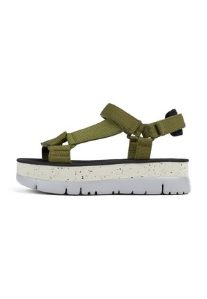 Sandal verde con tiras y una suela plataforma blanca moteada y una base de goma negra. Cuenta con tiras ajustables para un ajuste seguro.