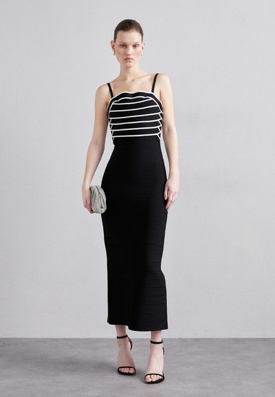 Abito nero con texture a righe verticali e corpetto a strisce bianche ondulate. Presenta spalline sottili ed è abbinato a una pochette testurizzata.