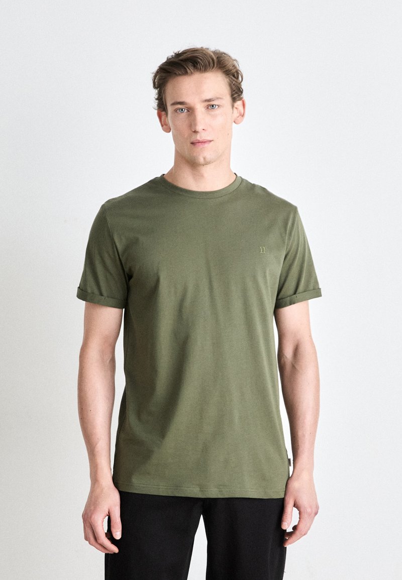 T-shirt de algodão verde-oliva com mangas curtas, decote redondo e detalhe de logotipo discreto no peito. Textura suave e ajuste relaxado.