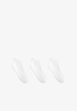 Trois paires de chaussettes basses blanches pour cheville avec un soutien de la voûte plantaire côtelé, disposées en rangée horizontale sur un fond blanc.