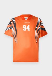 Orange sporttröja med korta ärmar i svart och vitt mönster. Har en vit "94" tryckt på framsidan och en Adidas-logotyp på bröstet.