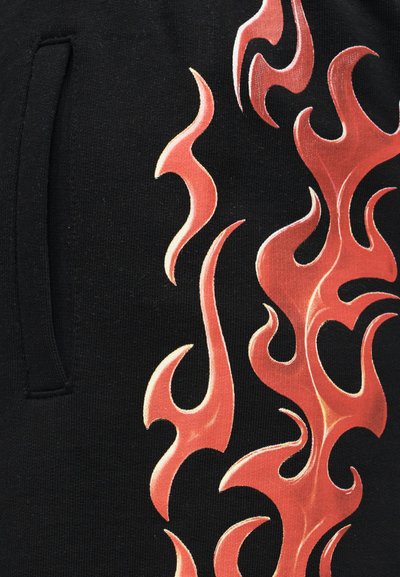 Μαύρο ύφασμα με πλαϊνή τσέπη και έντονο κόκκινο-πορτοκαλί σχέδιο φλόγας που εκτείνεται κατακόρυφα.