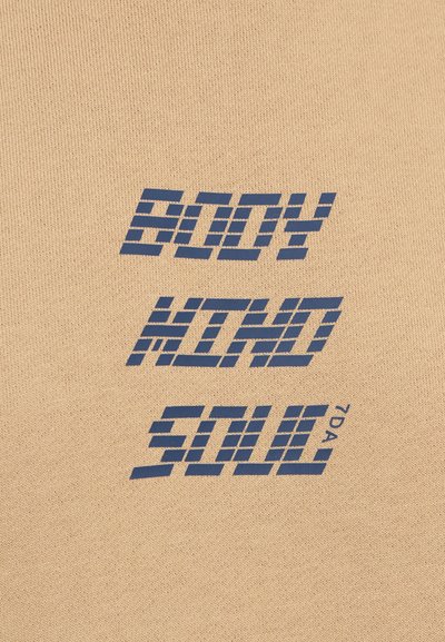 Beige fabric with a textured finish featuring blue graphic text: "BODY MIND SOUL" in a bold, blocky font with striped accents.