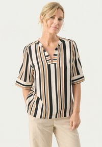 Creme- og sorte stribede bluse med korte ærmer og en udskåret hals. Lavet af letvægtsstof med lodrette striber i orange og brun.