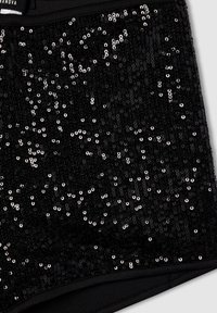 Tessuto nero con paillettes brillanti argentate che ricoprono la superficie, texture liscia con design aderente e vita elasticizzata.