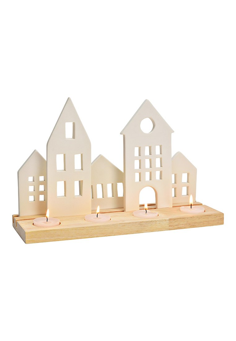 Portacandele in ceramica bianca a forma di case su una base in legno, con finestre intagliate e quattro candele tealight rosa.