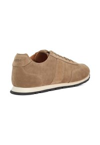 Brown suede sneakers with a low-profile design, rounded toe, and contrasting white sole. Features stitched accents and brand logo at the heel.