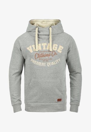 Szara bluza z kapturem i kremowym wnętrzem, z logo w stylu vintage. Posiada sznurki, przednią kieszeń oraz ściągacze przy mankietach.