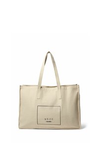 Beige Canvas-Tote mit zwei dünnen Griffen, die ein rechteckiges schwarzes Grafikdesign mit dem Text "still nordic" innerhalb des Rahmens zeigt.