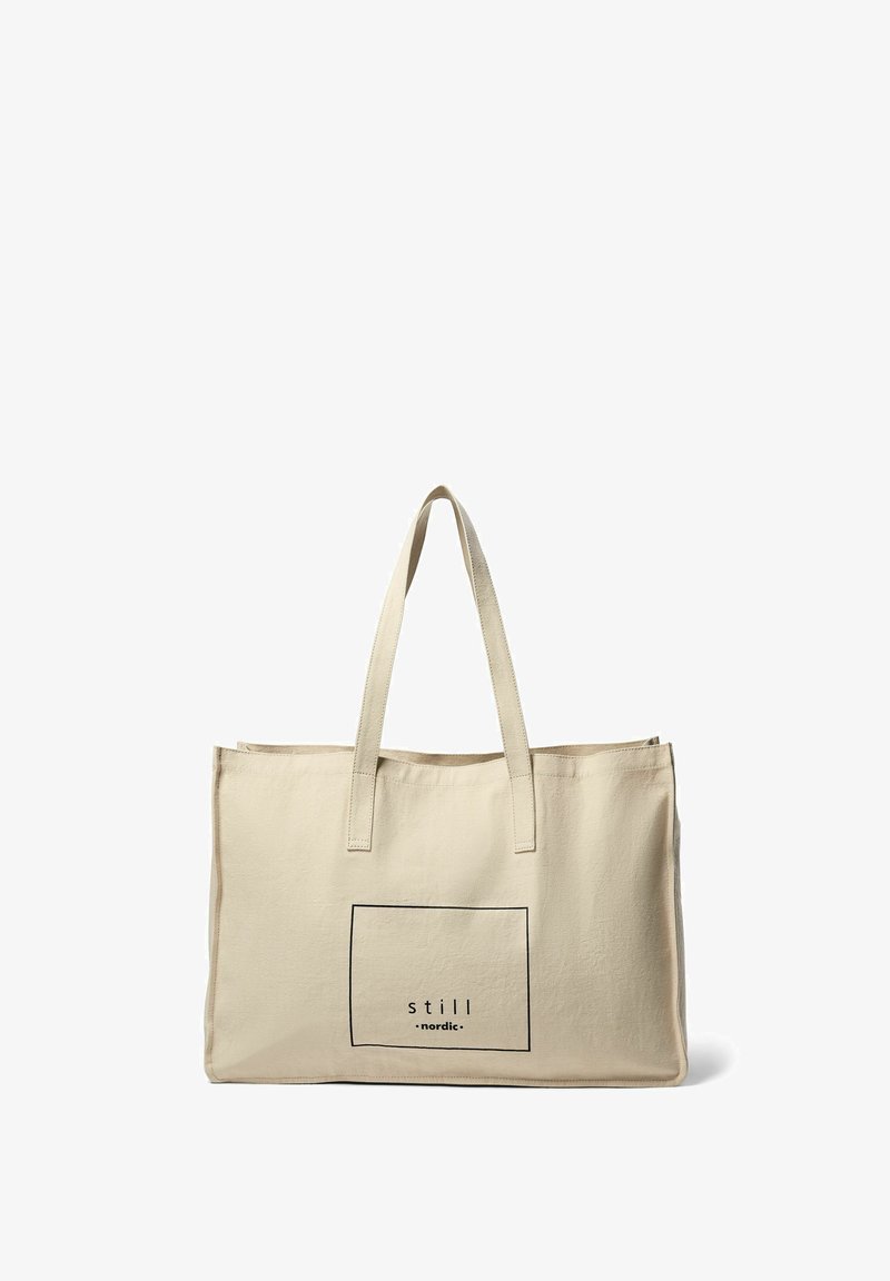 Bežna platnena torba z dvema tankima ročajema, ki ima pravokotno črno grafiko z besedilom "still nordic" znotraj obrobe.