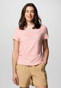 T-shirt di cotone rosa chiaro con grafica di un sole e testo "Sunny Days Columbia", abbinato a pantaloni kaki. Design con maniche corte e collo girocollo.