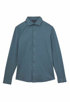 Camicia a maniche lunghe di un verde scuro, realizzata in tessuto morbido. Presenta un colletto classico, apertura con bottoni e orlo rotondo. Nessun motivo o dettaglio decorativo.
