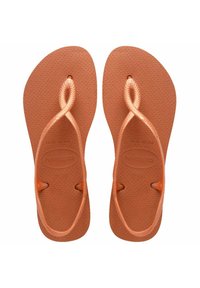 Ciabatte in gomma marroni con suole testurizzate e design della cinghia intrecciato. Contrassegnate con il logo "havaianas" e informazioni sulla taglia.