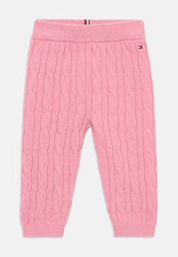 Pantaloni rosa in maglia con un motivo a treccia, vita elastica e polsini a costine. Include un piccolo logo vicino alla vita.