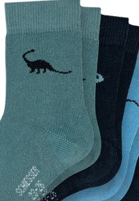 Fire par ribbede sokker i teal, mørkeblå, navy og lyseblå, med en sort dinosaur silhuet på det teal par.