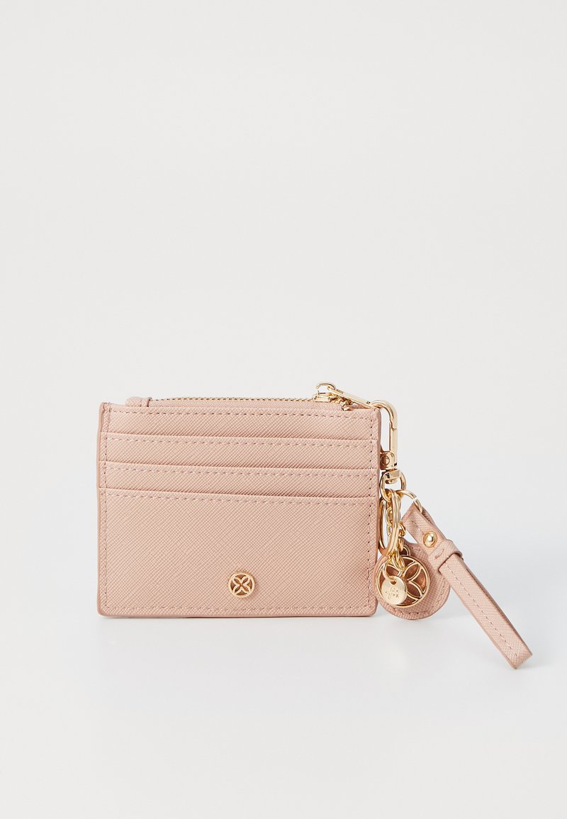 Compact pink cardholder made of textured material, featuring multiple card slots, a zippered pocket, and a gold-tone charm.
