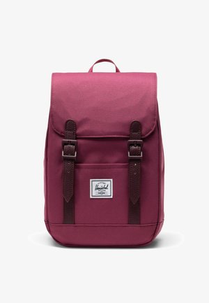 Bordeaux kleuren stoffen rugzak met een klep, bruine leren banden, voorvak en logo patch. Heeft stikdetails en een handvat aan de bovenkant.