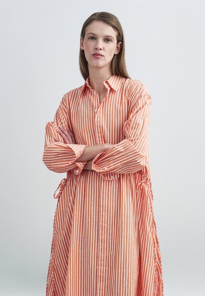 Πουκαμισοφόρεμα με πορτοκαλί ρίγες, κουμπιά μπροστά, μακριά μανίκια και ζωνάκι στη μέση. Μαλακό ύφασμα με άνετη εφαρμογή και σχεδιασμό μέχρι τον αστράγαλο.
