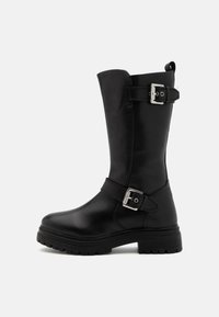 Botas altas de cuero negro hasta la rodilla con puntera redondeada, acentos de hebilla en el costado y una suela gruesa de goma que presenta un patrón de textura.