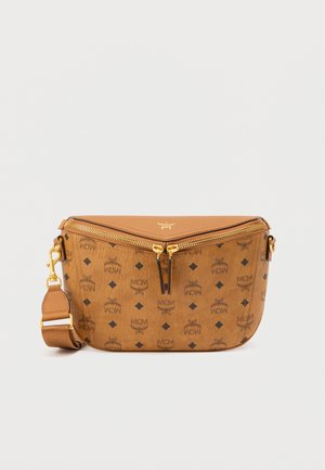 Bruine leren crossbodytas met gouden hardware, ritssluiting en herhalend zwart logopatroon. Verstelbare riem en gebogen vorm.