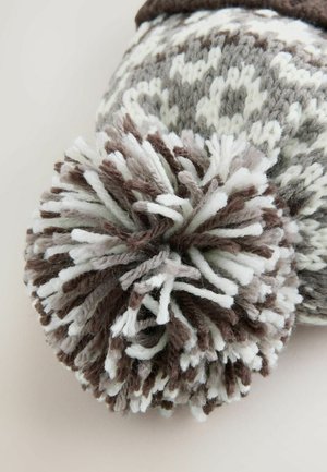 Bonnet tricoté en gris, marron et blanc, doté d'un grand pompon texturé sur le dessus avec des couches de fil et des motifs géométriques.
