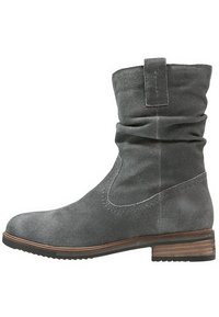 Bottine en suède grise avec un design flou, petit talon empilé, bout arrondi et détails à couture unique sur les côtés.