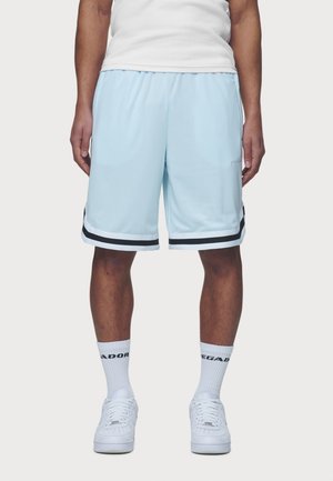 Hellblaue Sportshorts mit schwarzen Seitenstreifen, elastischem Bund und glattem Stoff. Getragen mit weißen Socken und Turnschuhen.