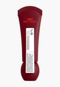 Tube de compression rouge avec une base courbée et un capuchon strié. Présente une étiquette blanche avec des informations sur le produit et des icônes. Le texte indique "SMB07 SWIPE 2 SMOOTH."