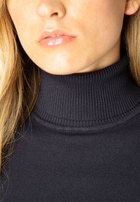 Donkerblauwe coltrui met een ribbeltextuur en een aansluitend ontwerp, met een hoge kraag en een gladde stof.