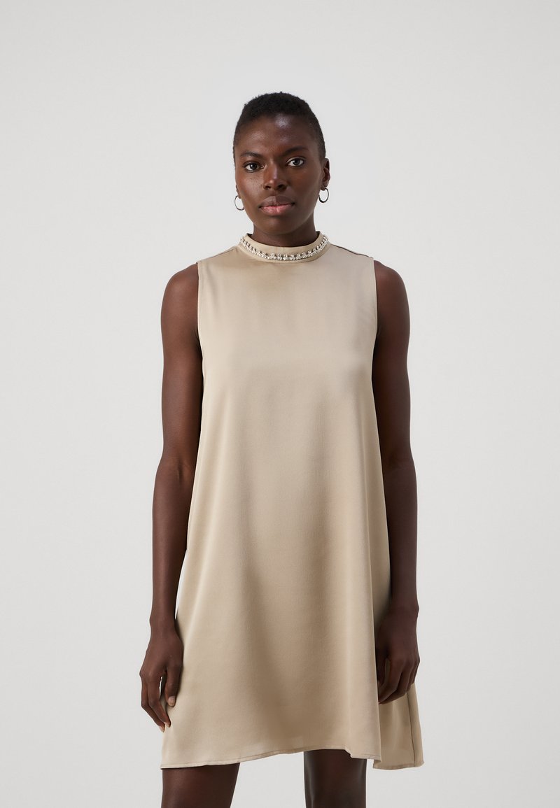 Vaaleanbeige ilmanhiha dress, jossa on korkea kaulus ja koristeellinen kauluskappale. Sujuva kangas A-linjaisessa muodossa, polvipituinen.