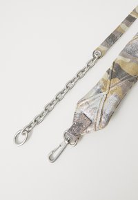 Stofrem med et camouflage mønster i beige, grå og grønne nuancer, med en sølvfarvet kæde og metalclips. 