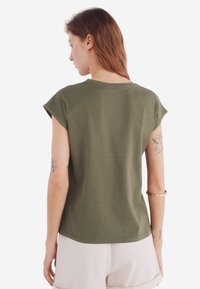 Olivenfarvet t-shirt med korte ærmer, rund halsudskæring og en afslappet pasform. Fremstillet af blødt stof med en glat overflade.