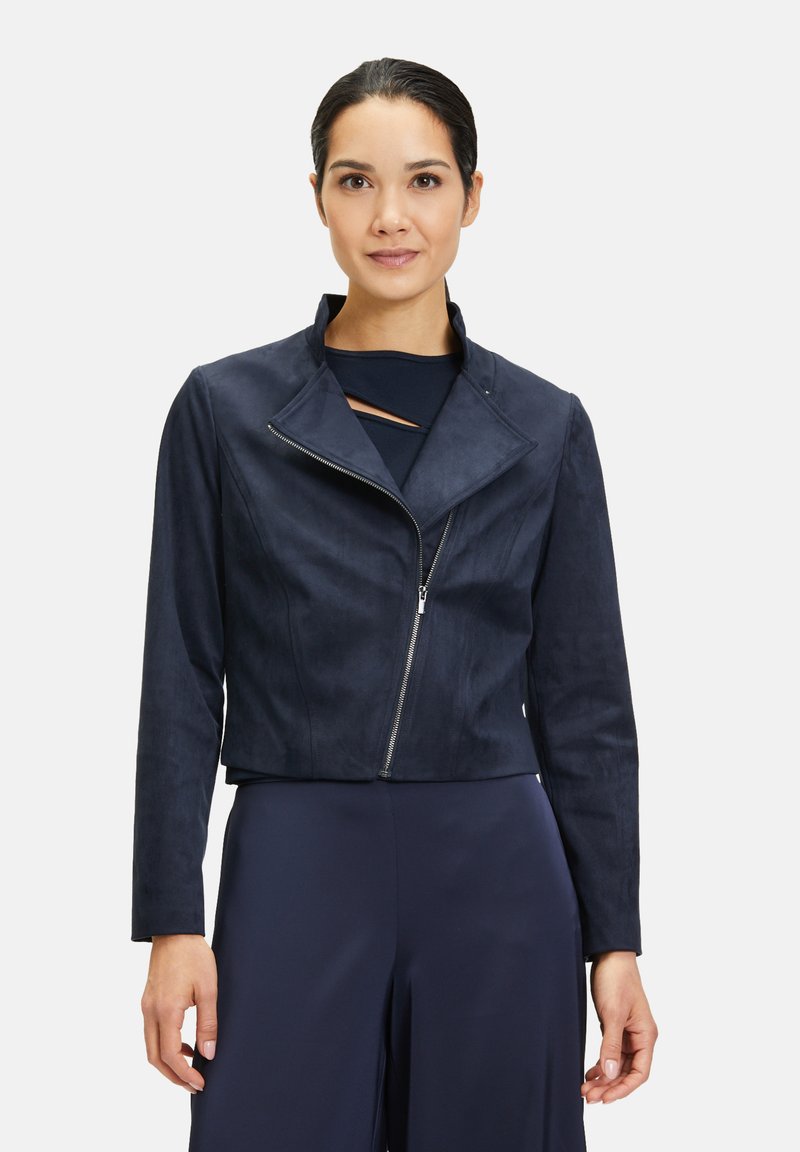 Marinblått cropped jacka i mjukt mockaliknande material med notchkrage och framdragkedja. Minimalistisk design med rena linjer.