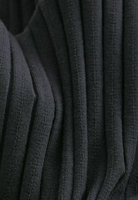 Texturiert schwarzer Stoff mit vertikalem Streifenmuster, das unterschiedliche Tiefen in den Rillen aufweist, eine weiche Erscheinung und einen leichten Glanz hat.