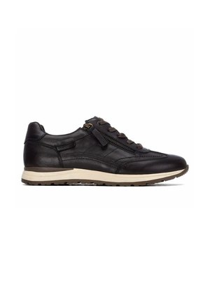 Zapatilla negra de cuero con cremallera lateral, cordones marrones y suela de goma blanca mostrada desde el lateral exterior sobre fondo blanco.
