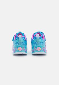 Akvablå sneakers med rosa detaljer, teksturerte mesh-paneler, bølget design og dekorative skjell- og stjernesymboler på hælen.