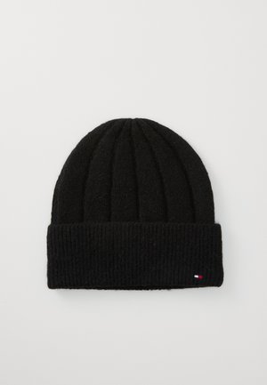Black knit beanie with ribbed texture and folded cuff. Features small branded accent in red, white, and blue on the side.