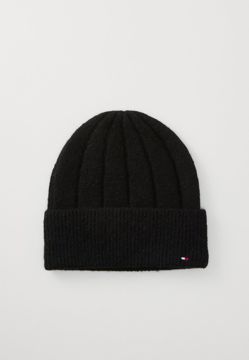 Black knit beanie with ribbed texture and folded cuff. Features small branded accent in red, white, and blue on the side.