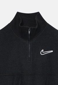 Černý fleecový pulovr se čtvrtinovým zipem, s žebrovaným stojáčkem a bílým vyšívaným logem Nike swoosh na hrudi.