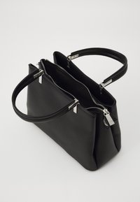 Bolso de mano de cuero negro con dos asas y un compartimento principal parcialmente abierto con cremallera, mostrado sobre un fondo blanco.