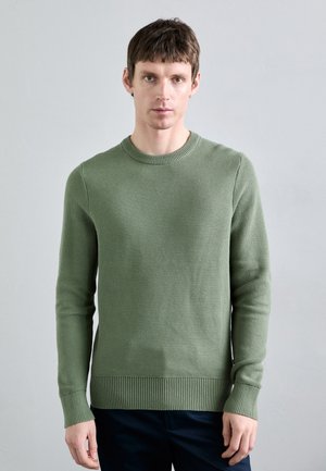 Groene gebreide trui met een ronde halslijn, ribbelmanchetten en een ribbelzoom. De textuur is geweven en heeft een subtiel patroon door het hele materiaal.