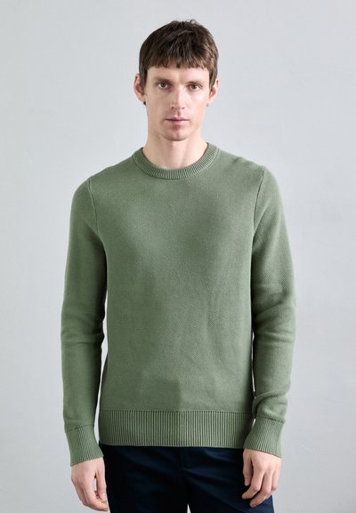 Maglione verde in maglia con scollo rotondo, polsini e orlo a costine. La texture è intrecciata, con un sottile motivo in tutto il tessuto.